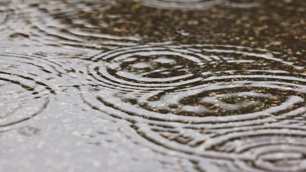 潮湿的天气场景，雨滴落在被水淹没的街道上视频素材