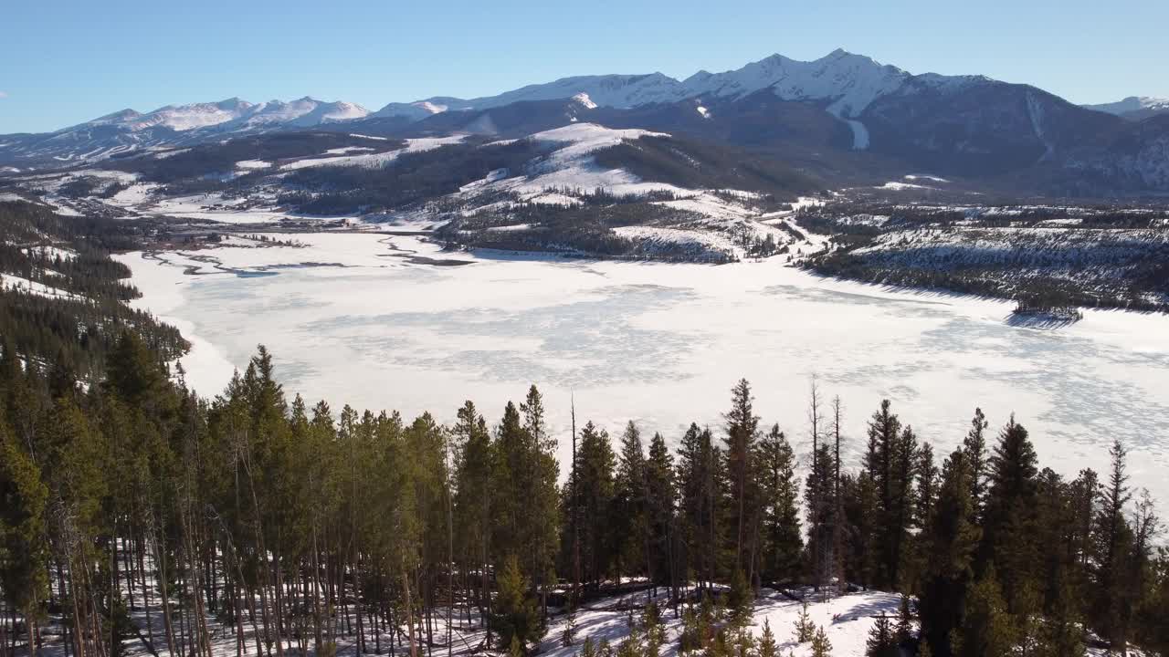 冰封的湖泊与积雪覆盖的山脉在背景，揭示视频素材