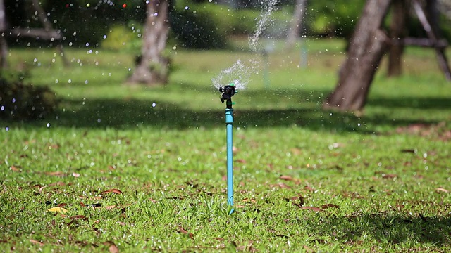 洒水装置。农业洒水车在后院的草地上喷水。视频下载