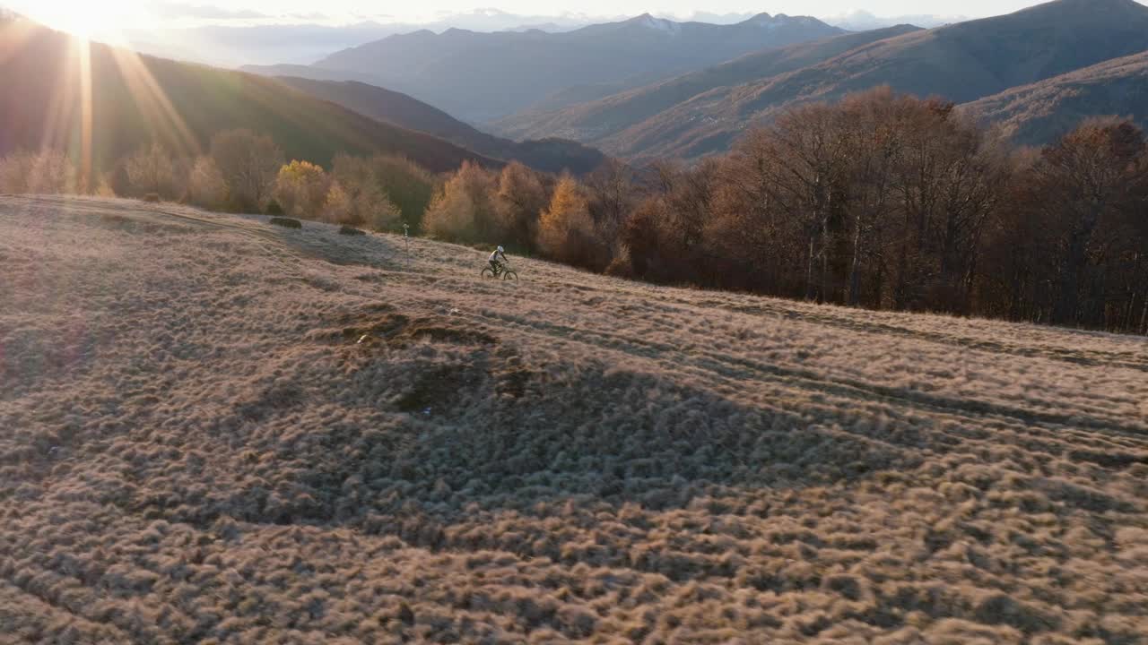 高空无人机拍摄高山山脊上的山地自行车手视频下载