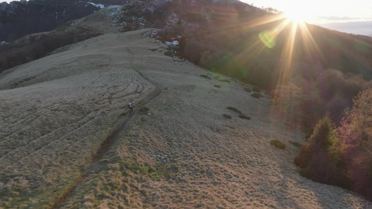 高空无人机拍摄高山山脊上的山地自行车手视频下载