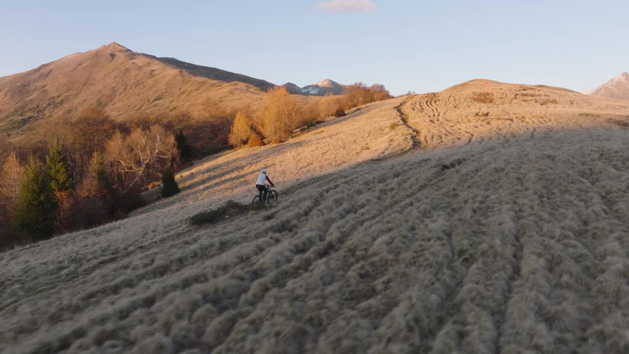 高空无人机拍摄高山山脊上的山地自行车手视频下载