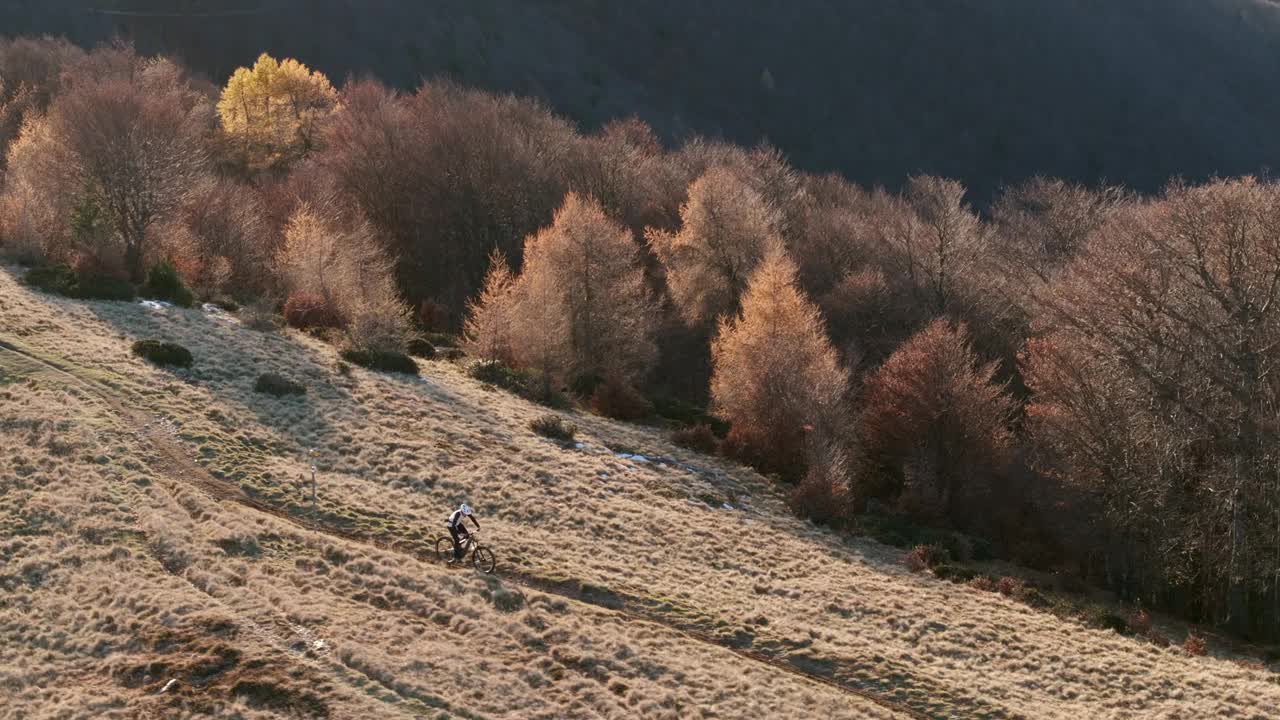 高空无人机拍摄高山山脊上的山地自行车手视频下载