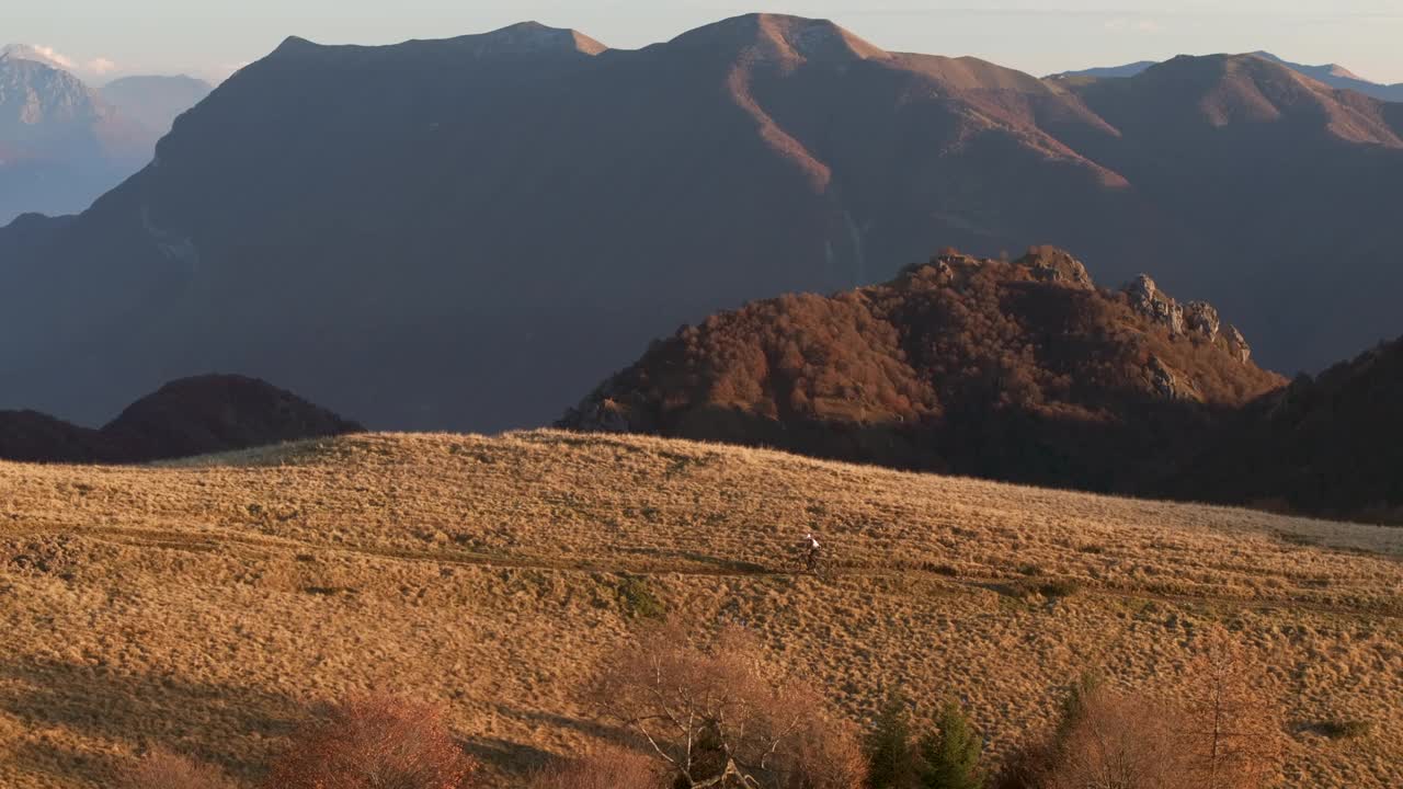 高空无人机拍摄高山山脊上的山地自行车手视频下载