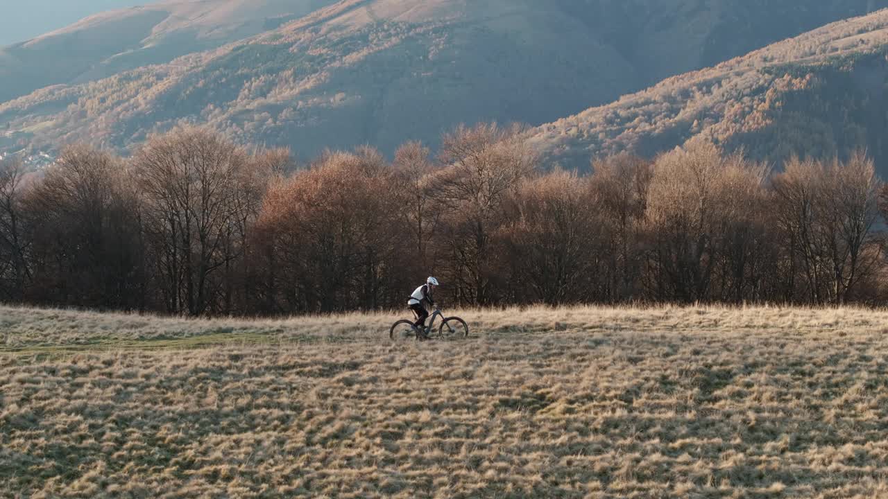 高空无人机拍摄高山山脊上的山地自行车手视频下载