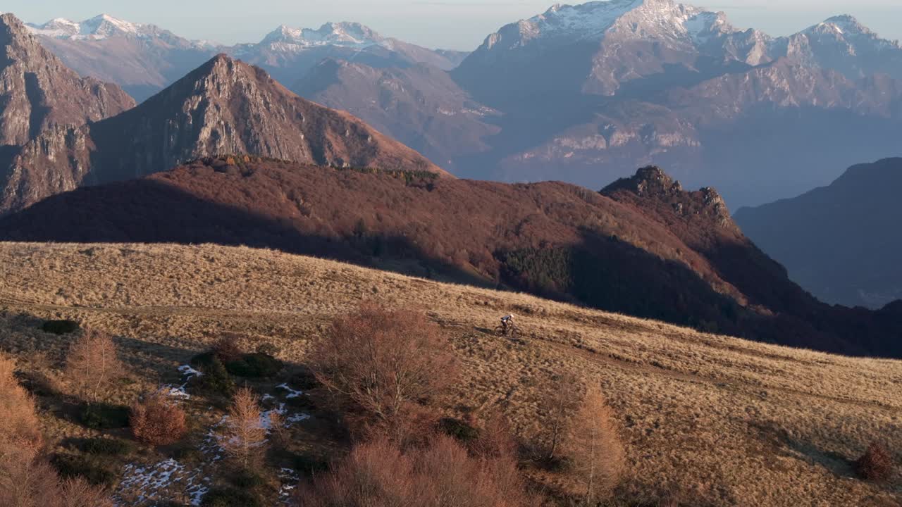 高空无人机拍摄高山山脊上的山地自行车手视频下载