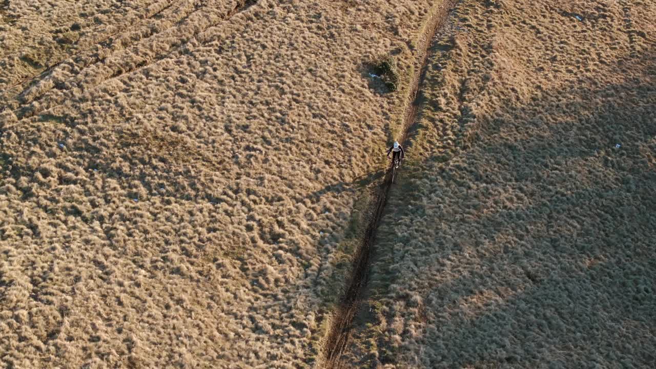 高空无人机拍摄高山山脊上的山地自行车手视频素材