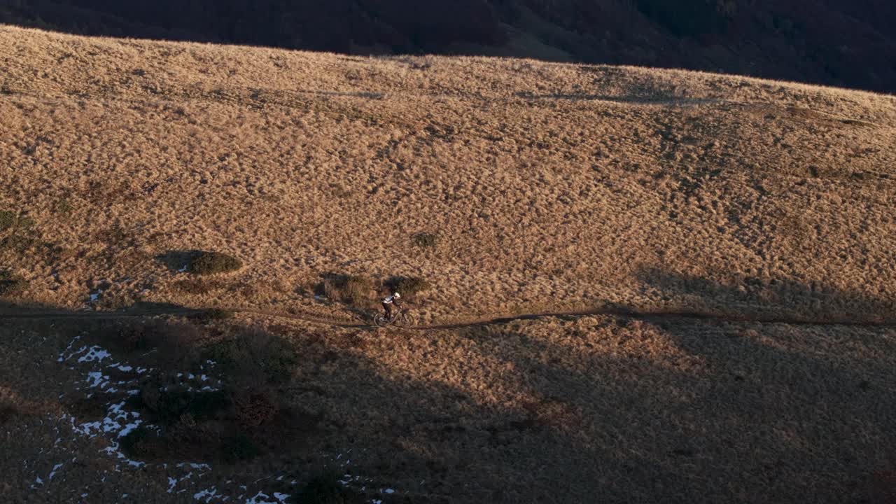 高空无人机拍摄高山山脊上的山地自行车手视频素材