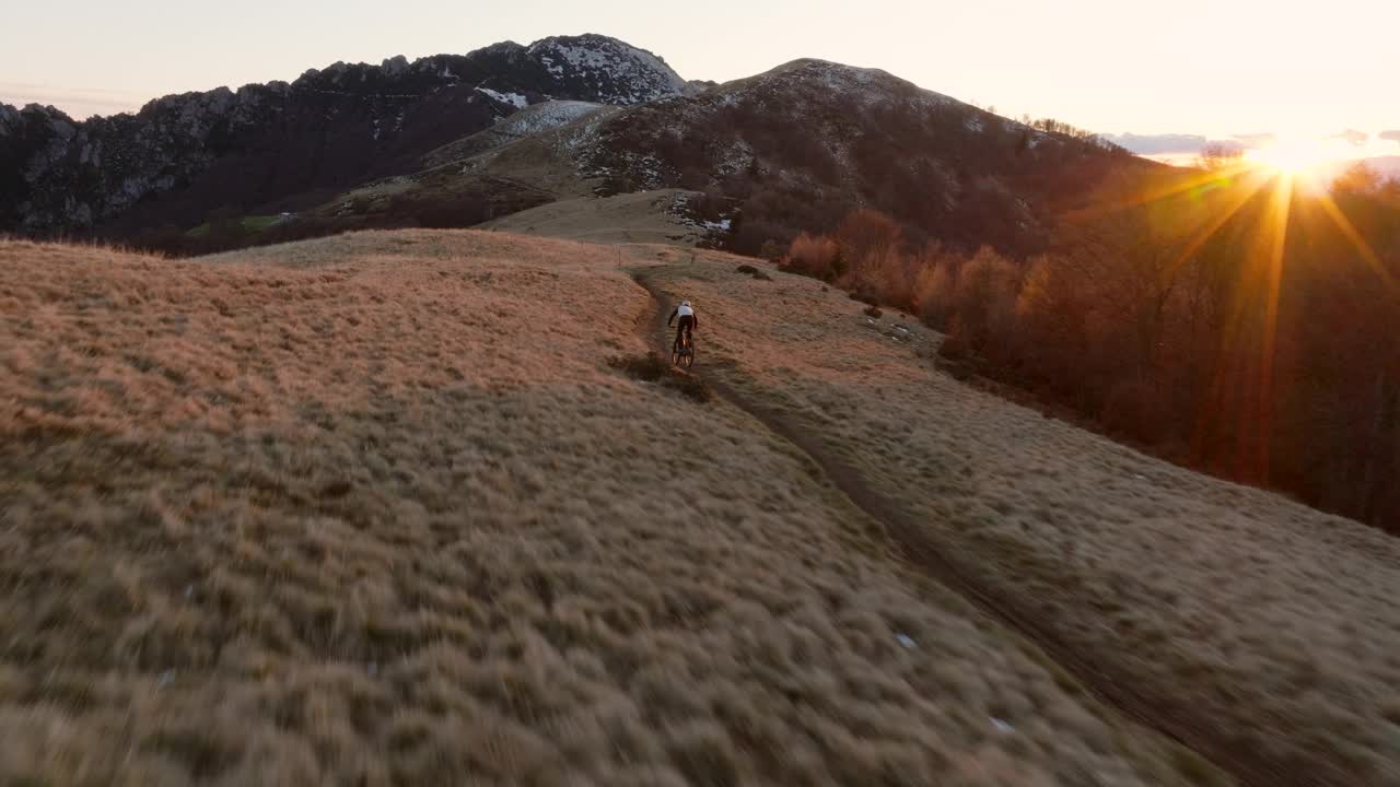 高空无人机拍摄高山山脊上的山地自行车手视频下载