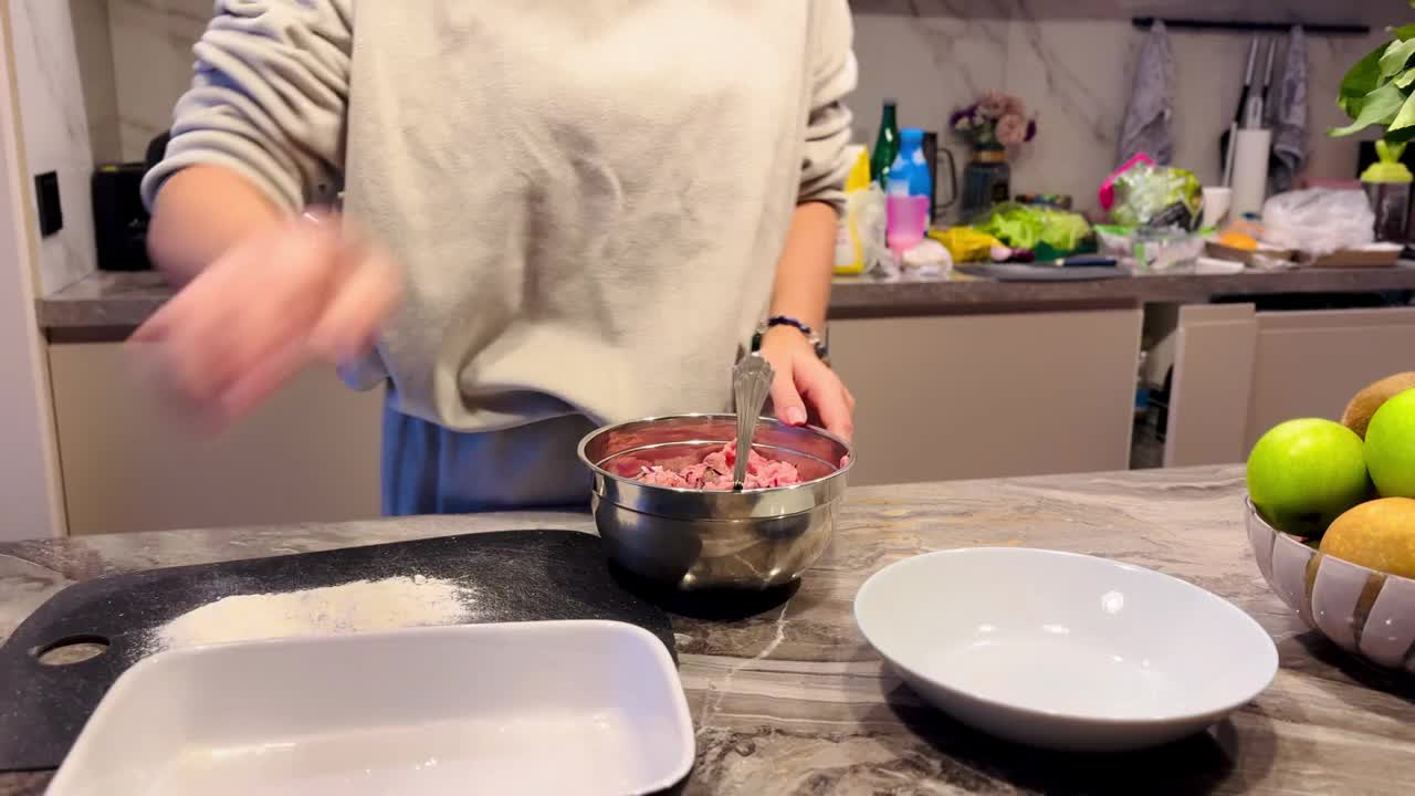 女孩把自制的肉末混合在一起做成肉排视频素材