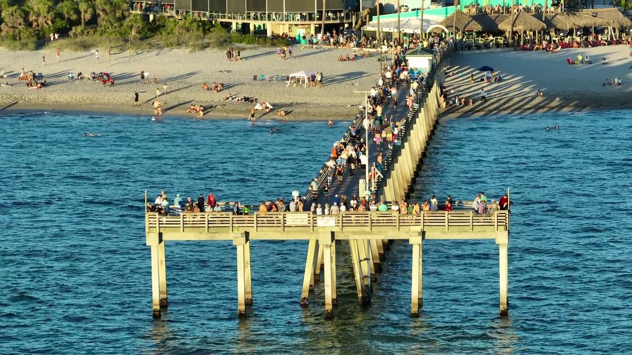 许多游客在威尼斯钓鱼码头享受假期的鸟瞰图。海滨夏日活动视频素材