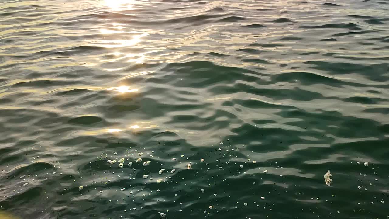 日落时平静的地中海，在希腊轻松而温暖的气氛中，阳光反射在海浪上闪闪发光视频素材