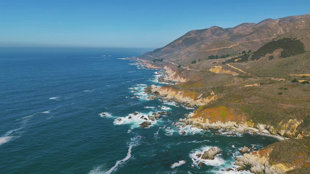 大苏尔海边的海岸线有波浪和蓝绿色的海水。著名的加州旅游目的地，沿太平洋1号公路，有沙滩和岩层。宽全景和风景秀丽的美国自然纪录片无人机4K UHD。视频素材