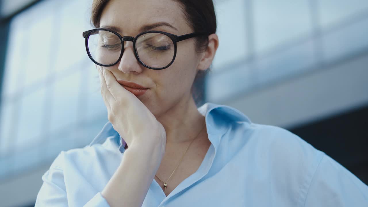 悲伤的女人摸着脸颊感到牙痛，需要去看牙医视频下载