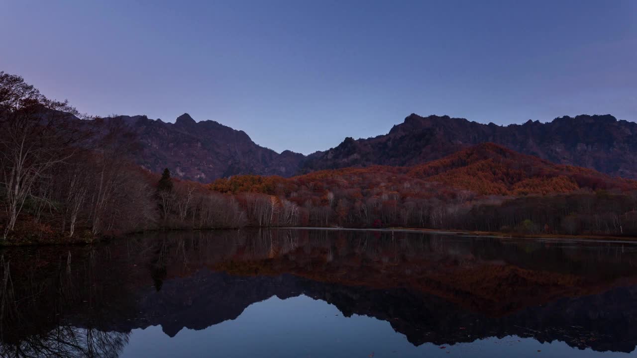 鸟居高地鸟居山的时间流逝，秋天的树叶沐浴在早晨的阳光中，反射在神池里视频素材