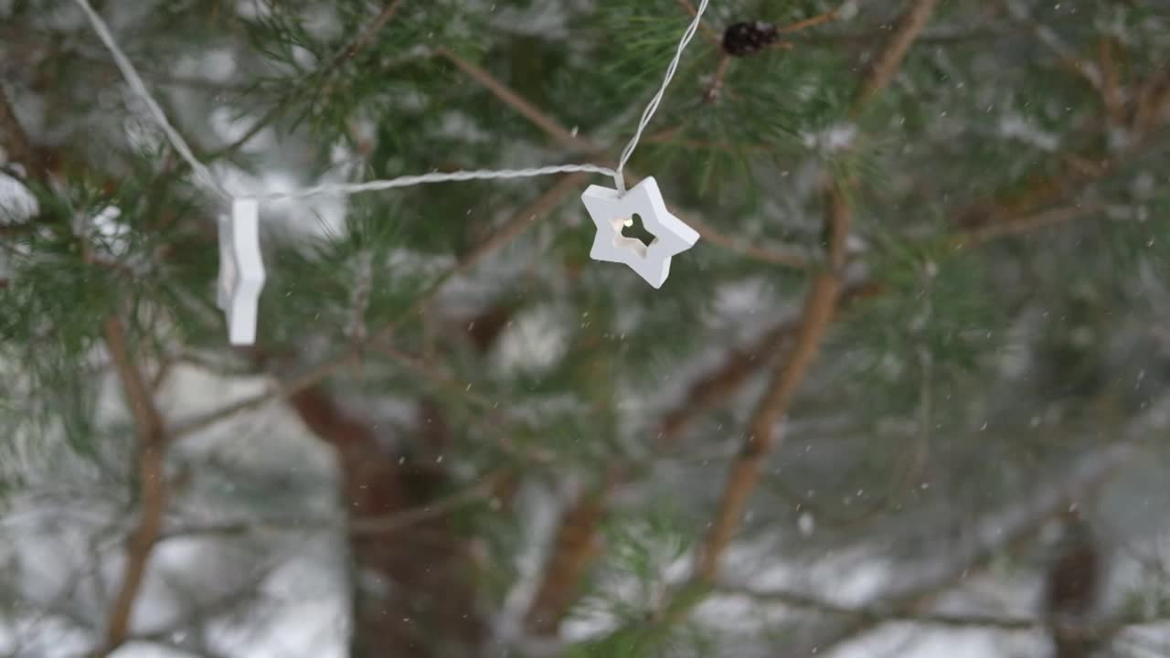 圣诞彩灯挂在常青树松树。冬天常绿的冷杉树枝和许多飘落的雪尘。降雪超级慢动作。白雪皑皑的云杉。自然背景视频片段视频素材