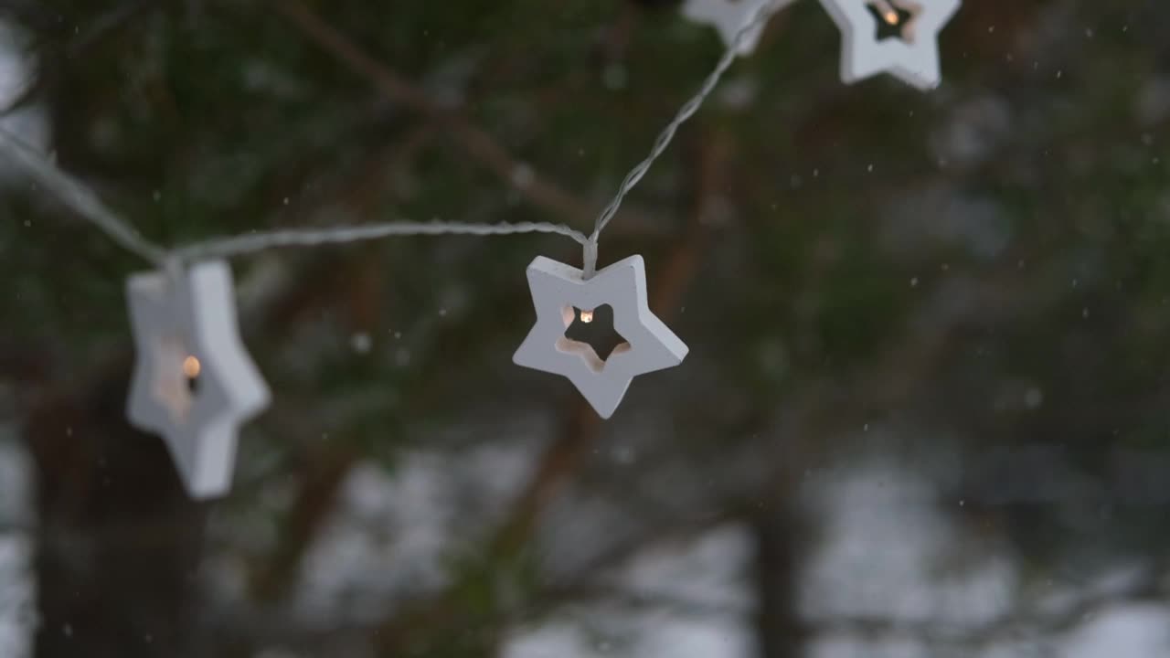 圣诞彩灯挂在常青树松树。冬天常绿的冷杉树枝和许多飘落的雪尘。降雪超级慢动作。白雪皑皑的云杉。自然背景视频片段视频素材