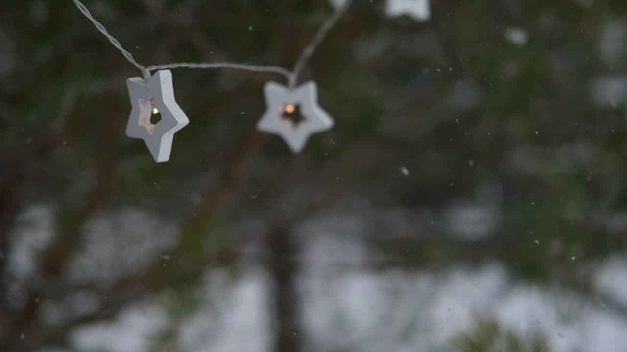 圣诞彩灯挂在常青树松树。冬天常绿的冷杉树枝和许多飘落的雪尘。降雪超级慢动作。白雪皑皑的云杉。自然背景视频片段视频素材