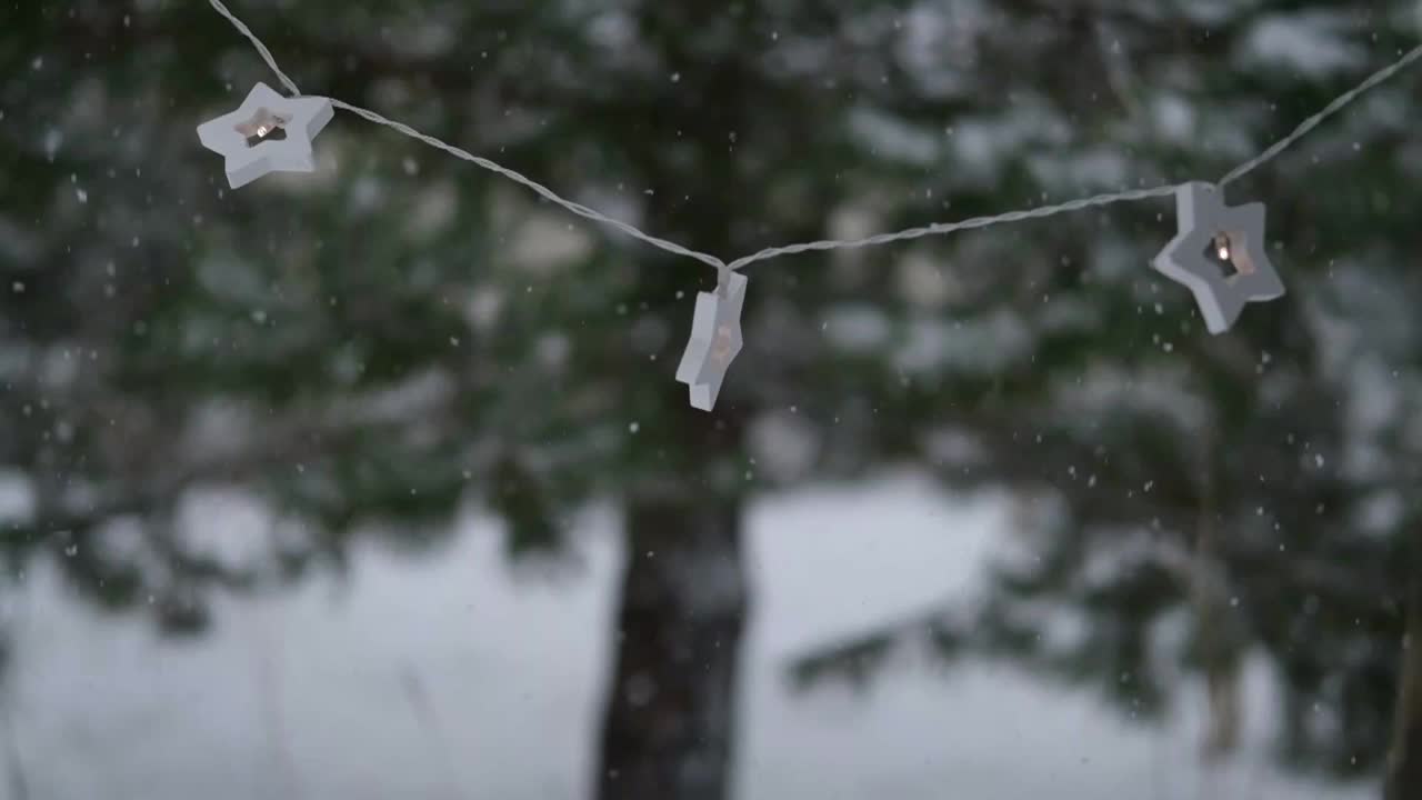 圣诞彩灯挂在常青树松树。冬天常绿的冷杉树枝和许多飘落的雪尘。降雪超级慢动作。白雪皑皑的云杉。自然背景视频片段视频素材