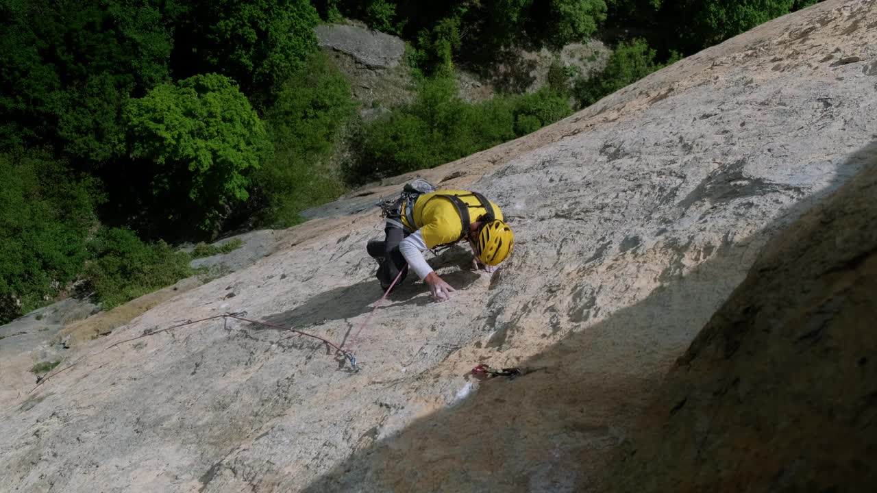 一个孤独的冒险家攀登崎岖山峰的雄伟山峰视频素材