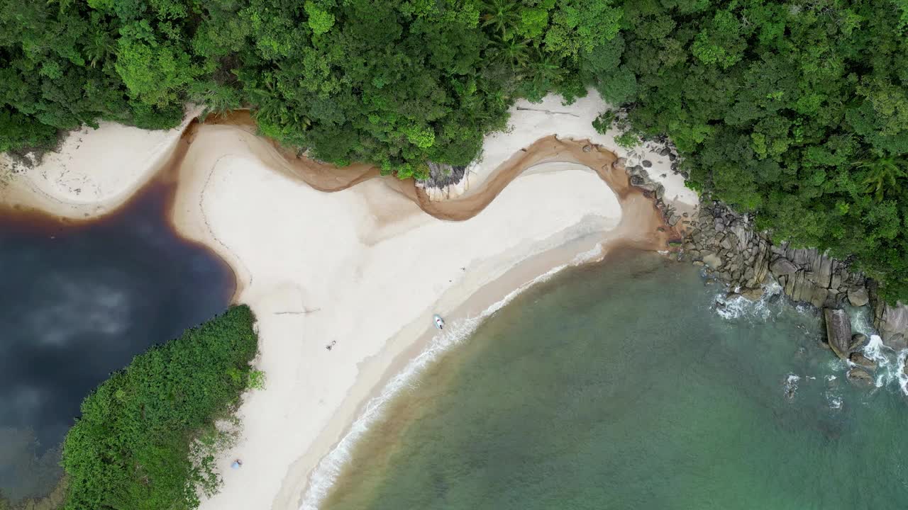 鸟瞰海岸的一个海滩，有波浪，岩石，多云的天空视频素材