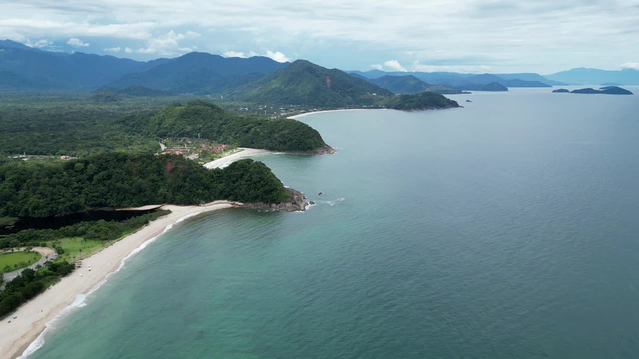 鸟瞰海岸的一个海滩，有波浪，岩石，多云的天空视频下载