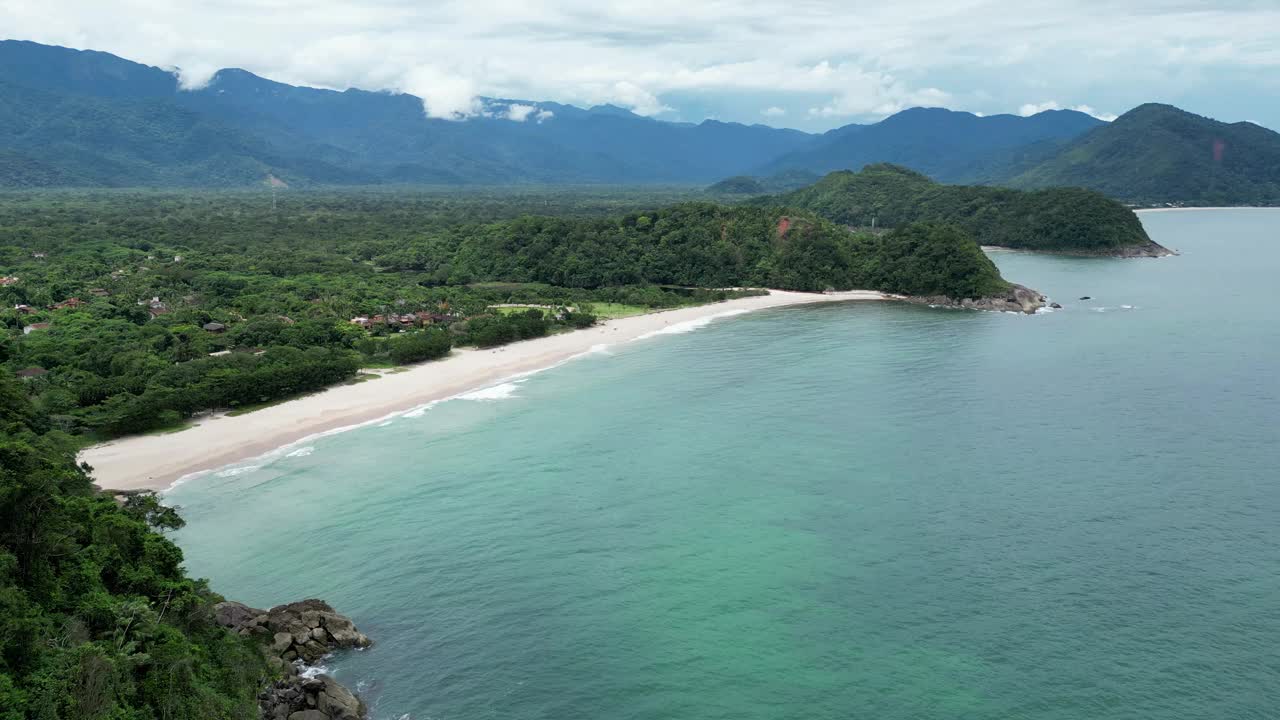 鸟瞰海岸的一个海滩，有波浪，岩石，多云的天空视频下载