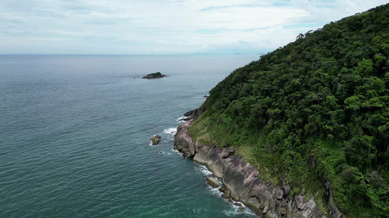 鸟瞰海岸的一个海滩，有波浪，岩石，多云的天空视频素材