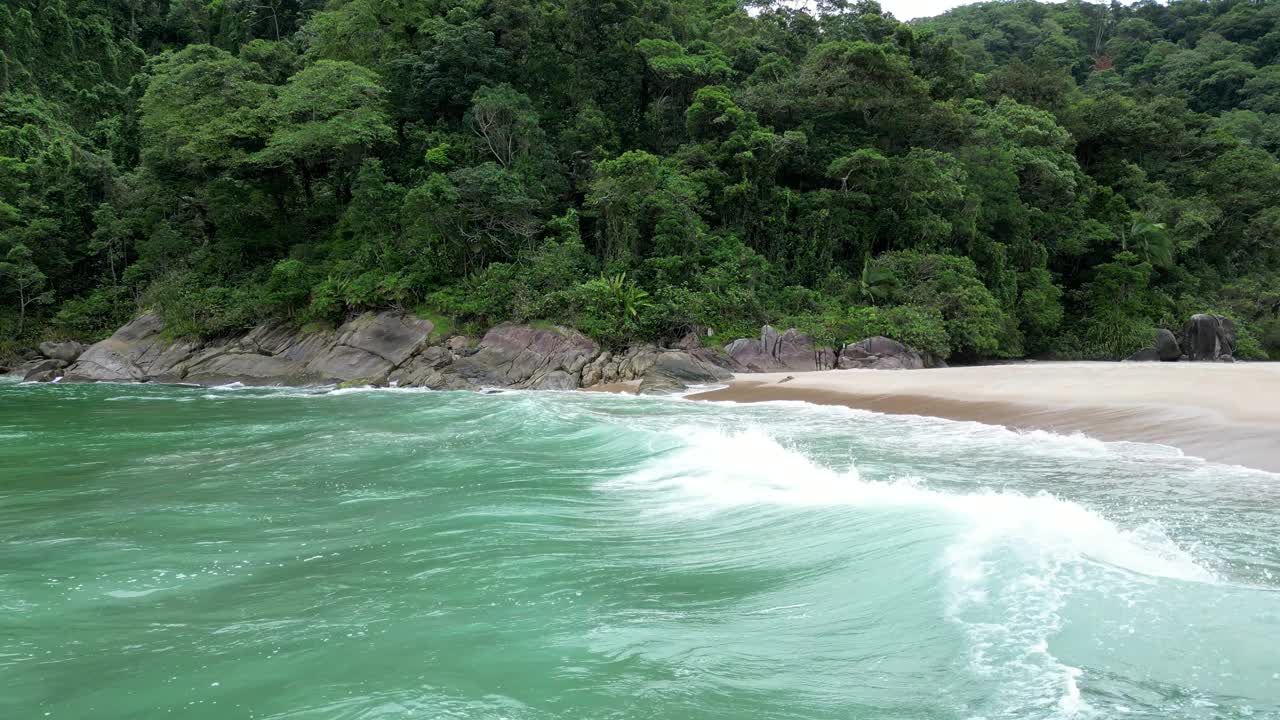 鸟瞰海岸的一个海滩，有波浪，岩石，多云的天空视频下载