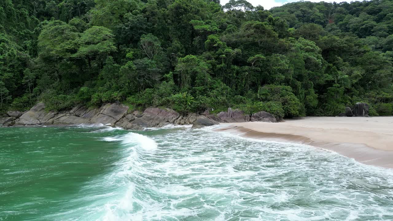 鸟瞰海岸的一个海滩，有波浪，岩石，多云的天空视频素材