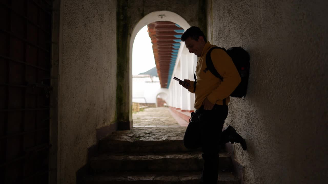 年轻的旅行者在历史悠久的殖民城市使用手机视频素材