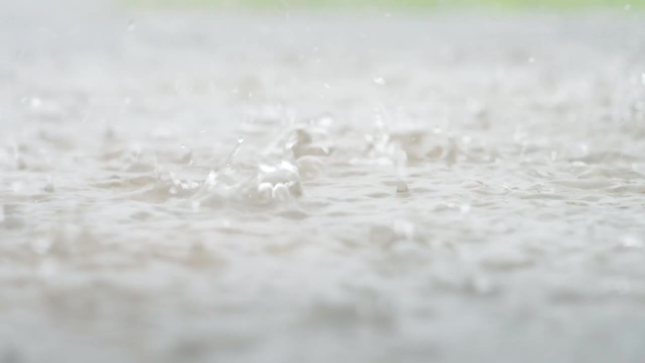 一个城市暴雨的大气视频。大雨和溅起的水坑从低点拍摄。视频素材