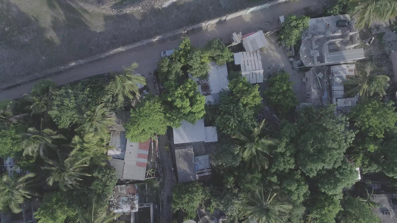 在日落时，牙买加德雷珀斯浓密的绿树之间的沿海建筑的高无人机镜头视频素材