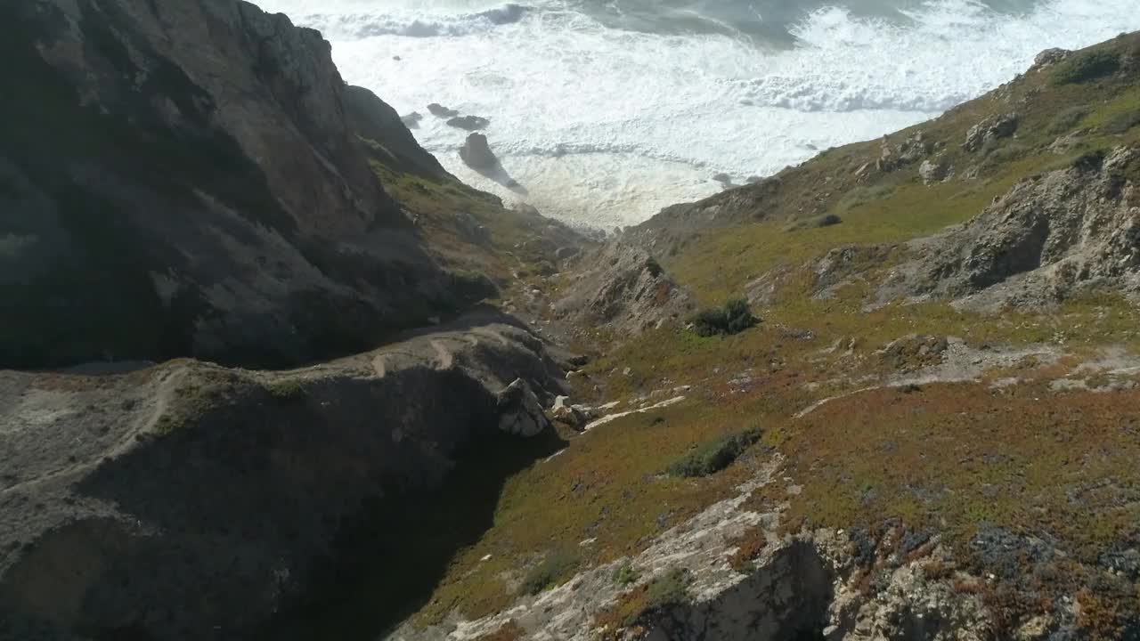 无人机拍摄的遥远的大熊海滩(Praia da Ursa)在一个阳光明媚的日子在葡萄牙罗卡角视频素材