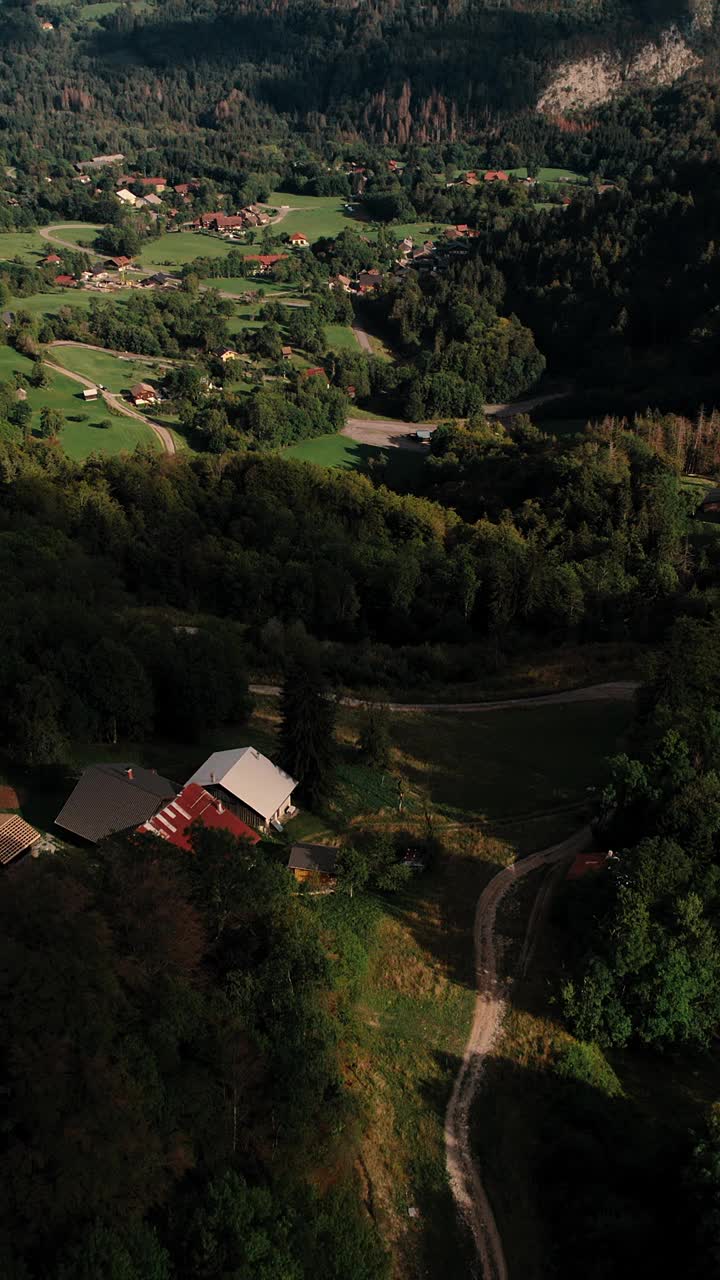 垂直无人机拍摄的山腰村庄的房屋，背景是石灰岩山脉视频素材