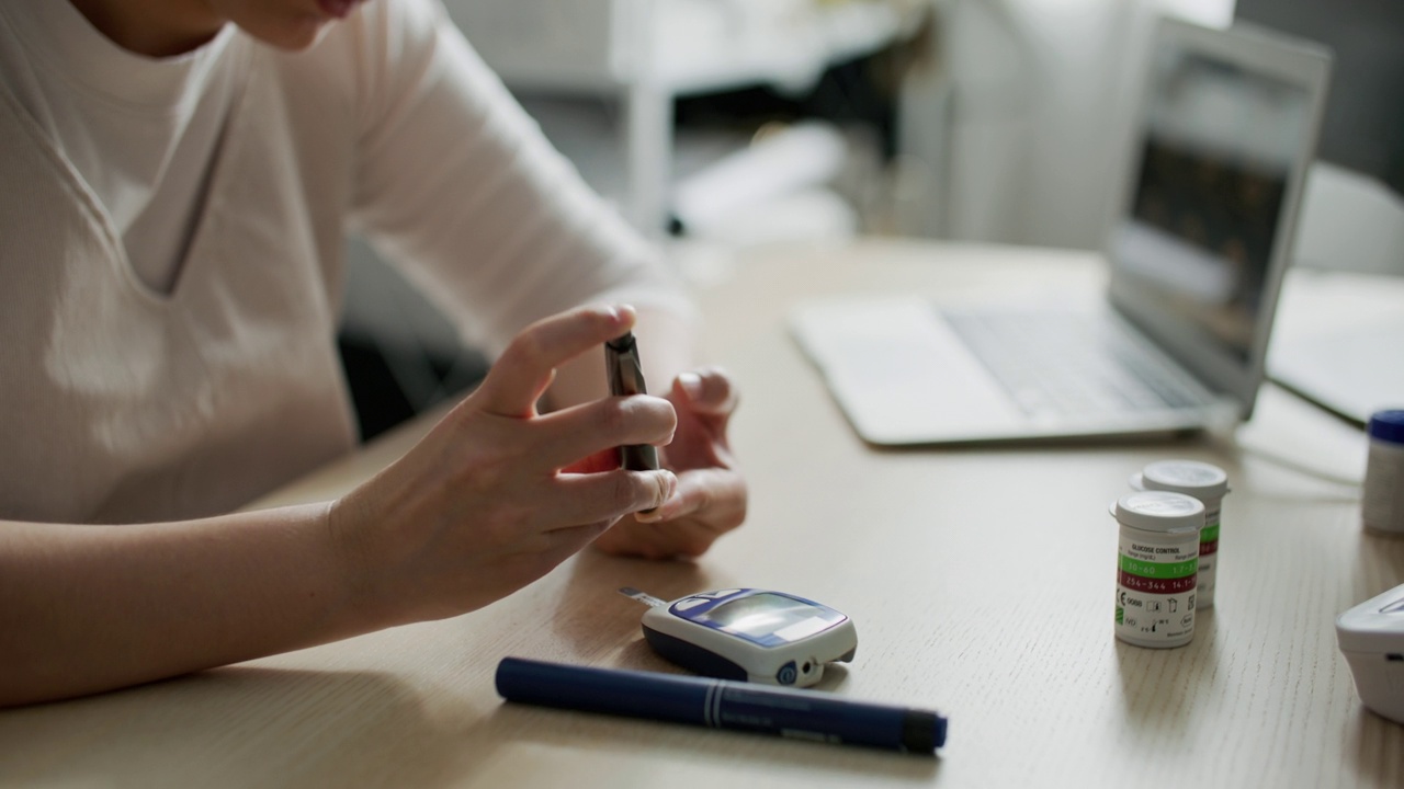 一名妇女用血糖仪检查糖尿病患者的血糖视频素材