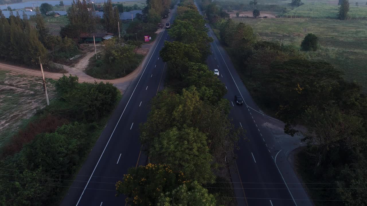 清晨用车辆在森林中移动鸟瞰乡村交通道路视频素材