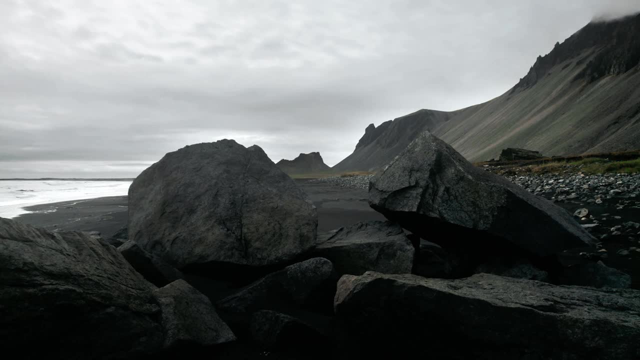 飞越岩石形成的黑色沙滩上的鹳鸟，火山山景观视频素材