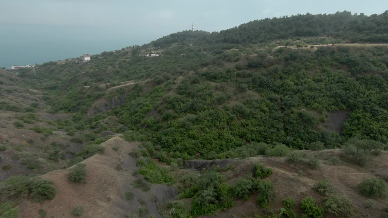 山与海地平线和灯塔的俯视图。射杀。风景优美，海岸上有山，远处有海。视频素材