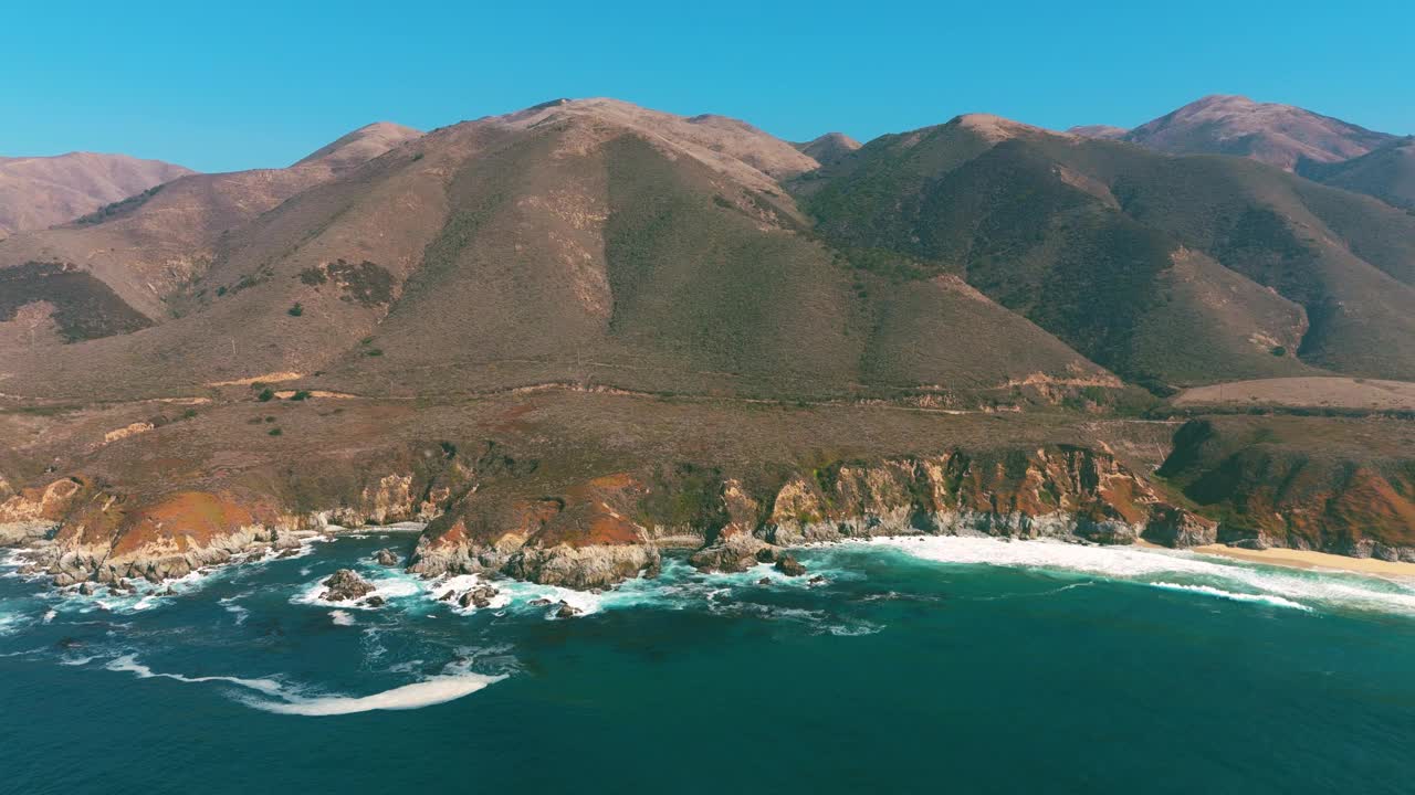 大苏尔海边的海岸线有波浪和蓝绿色的海水。著名的加州旅游目的地，沿太平洋1号公路，有沙滩和岩层。宽全景和风景秀丽的美国自然纪录片无人机4K UHD。视频素材