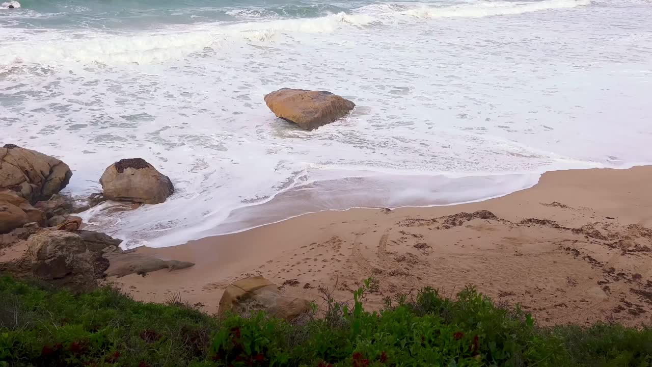 海浪冲击海岸线上雄伟的天然岩层的视频。无情的海浪遇到了崎岖的风化岩石。原始自然概念。视频素材