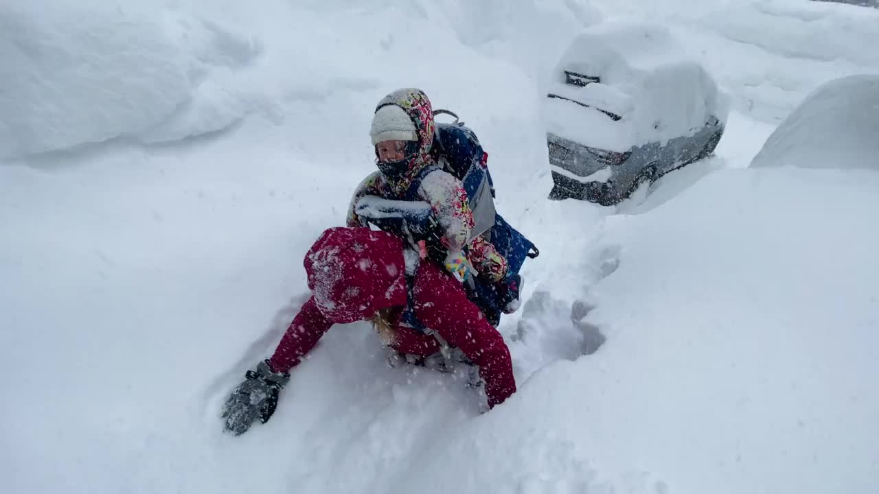 坚强的妈妈带着孩子在雪地里背包旅行视频下载