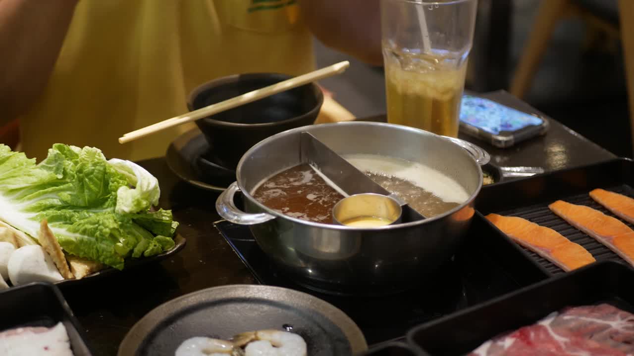 火锅涮锅与多种蔬菜在沸腾的火锅汤中烹煮的特写。日本亚洲美味健康火锅涮食品视频素材