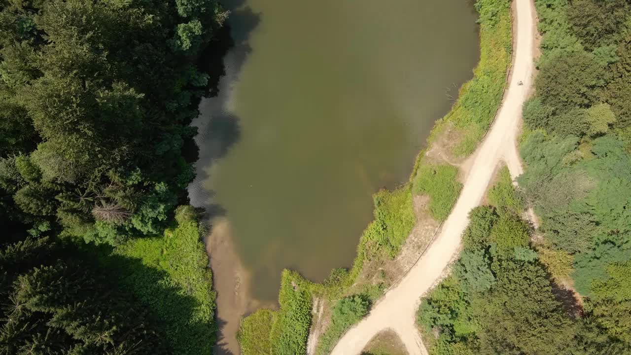 无人机直接在塞尔维亚的拉达尔湖和周围的树林上空飞行视频素材