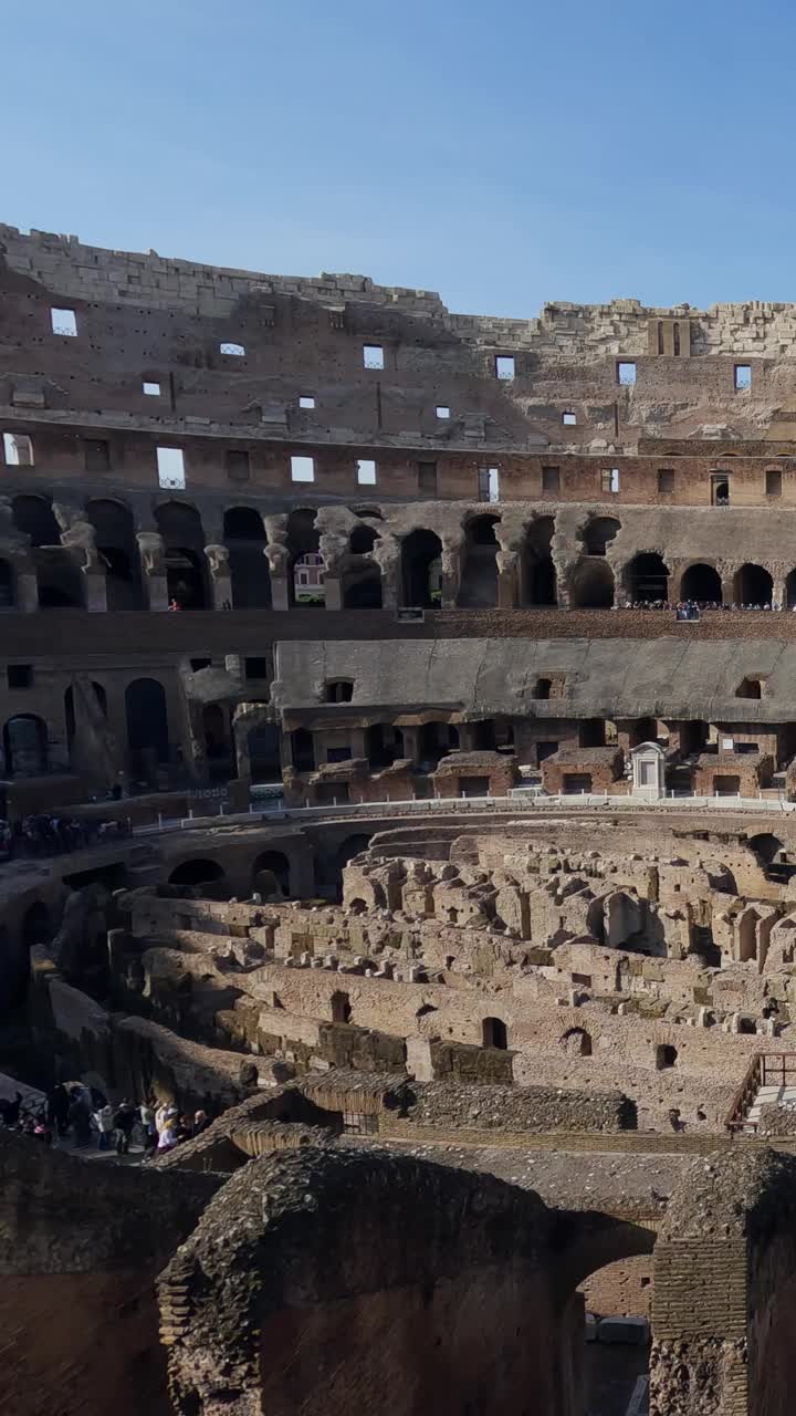在阳光明媚的夏日，垂直方向，游客在参观罗马著名地标古罗马斗兽场竞技场内部的超时间流逝视频素材