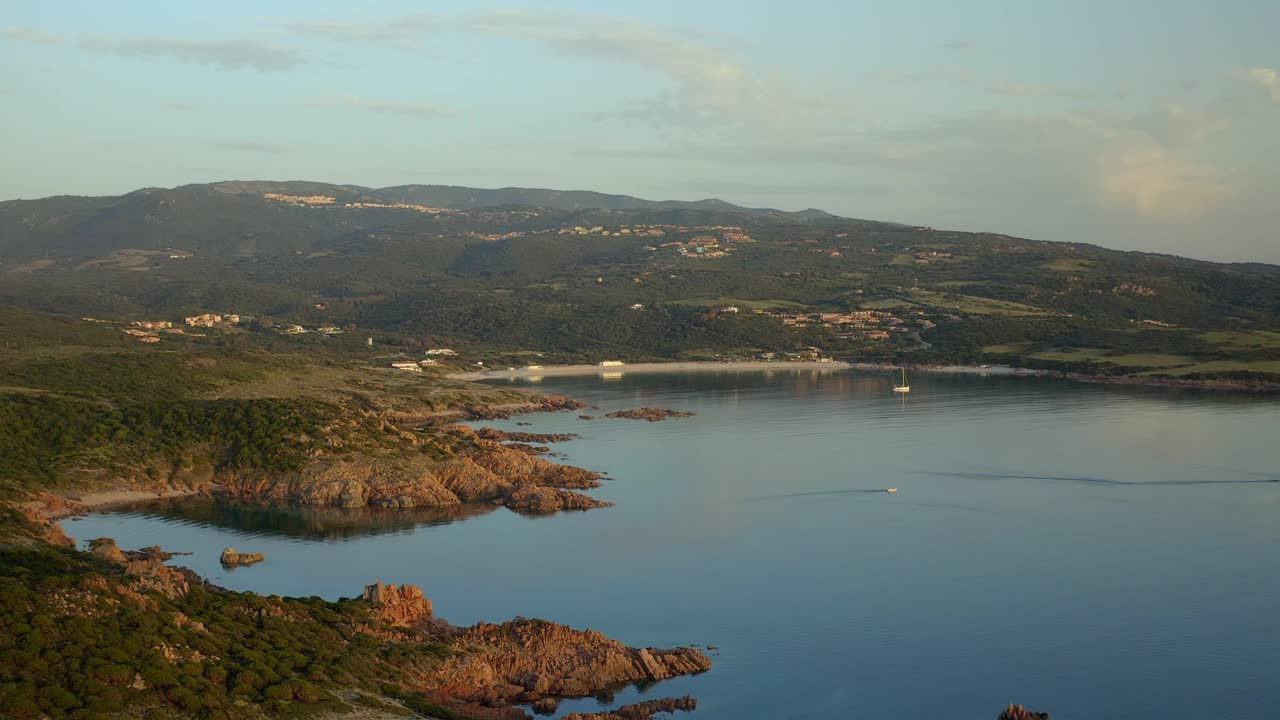 日落时分，意大利撒丁岛Isola Rossa海滩地区Punta Canneddi红色岩石景观的无人机鸟瞰图视频素材