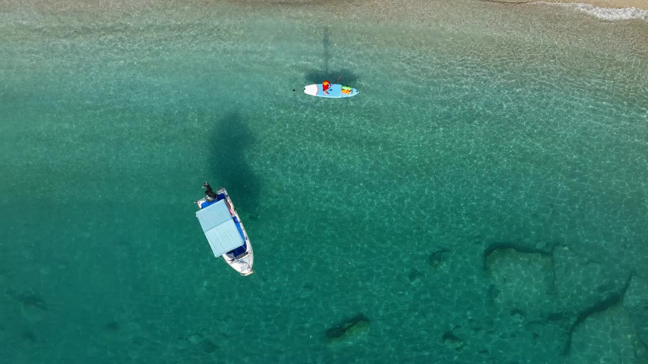 锚定的船和人站在站立桨板上从无人机的海景。地中海风景。视频素材