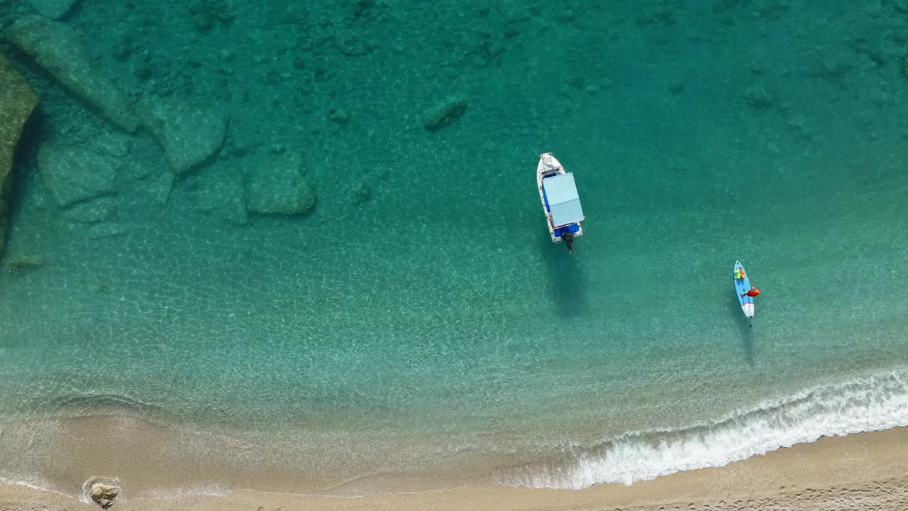 锚定的船和人站在站立桨板上从无人机的海景。地中海风景。视频素材