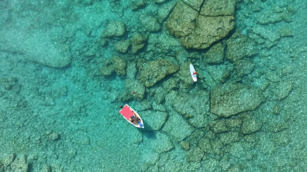 锚定的船和人站在站立桨板上从无人机的海景。地中海风景。视频素材