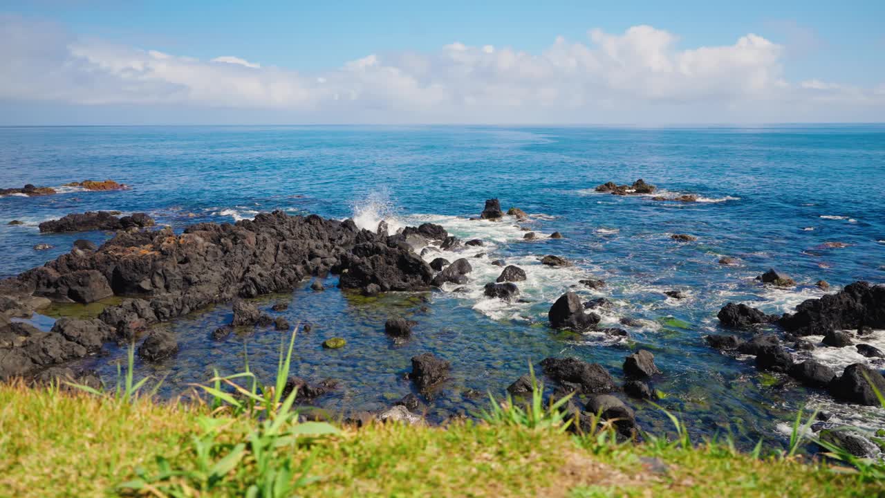 慢动作静态特写拍摄汹涌的海浪冲击着火山岩海岸线。蓝绿色的海水拍打着海岸。晴天，晴空万里。视频素材